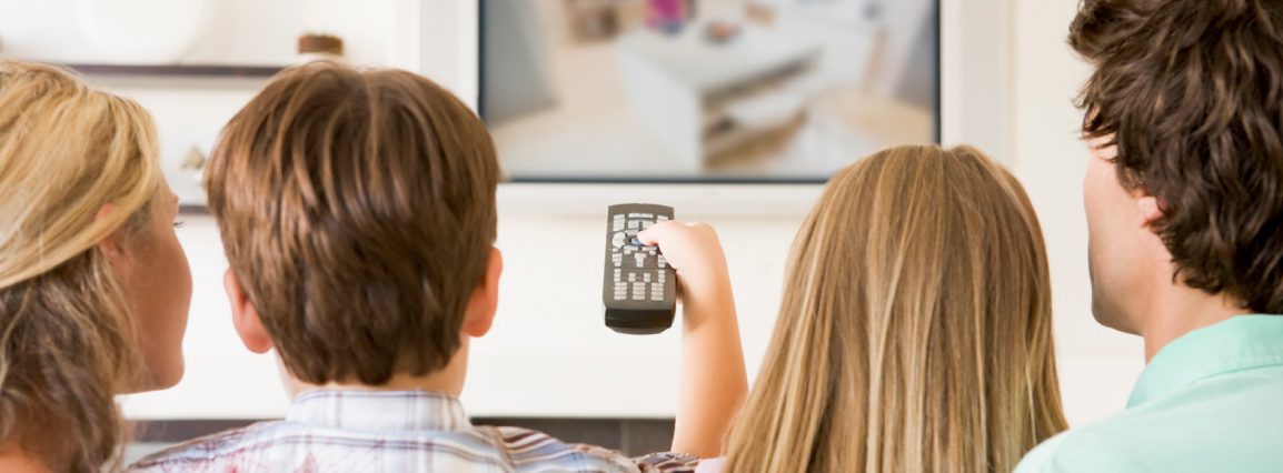 Family watching TV in living room