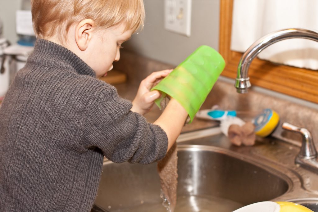 Kid washing dish in sink