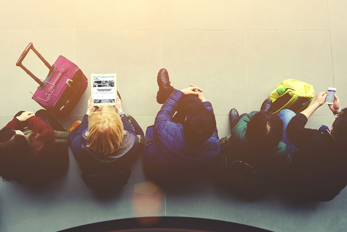 People at airport with tablet and cellphone.