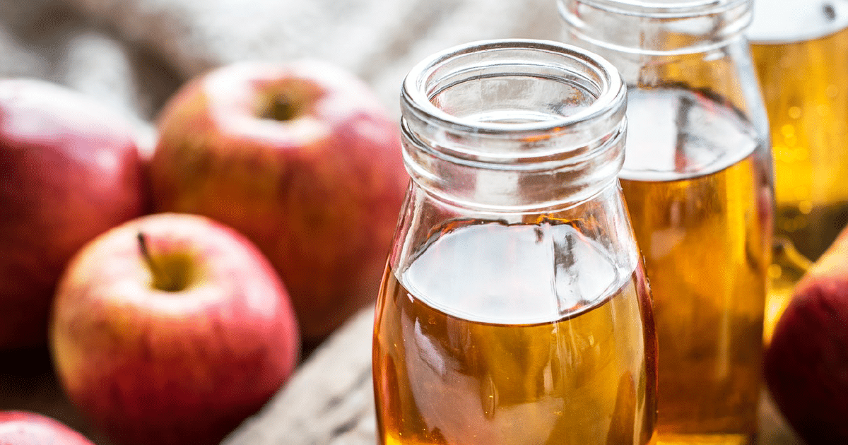 Jars of apple juice and red apples