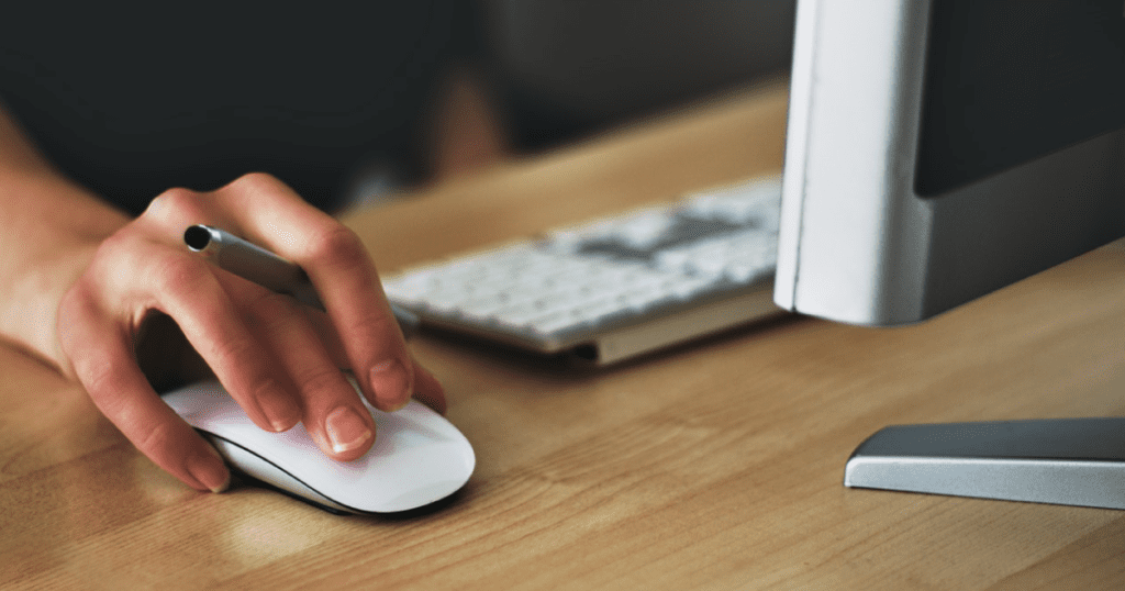 A person's hand on a computer mouse.