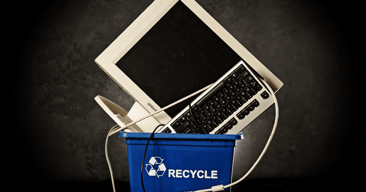 Computer sitting in a recycling bin.