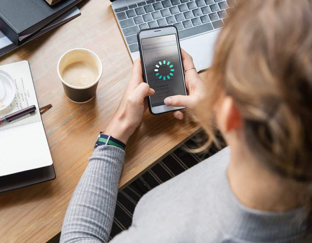 Woman looking at phone with loading symbol.