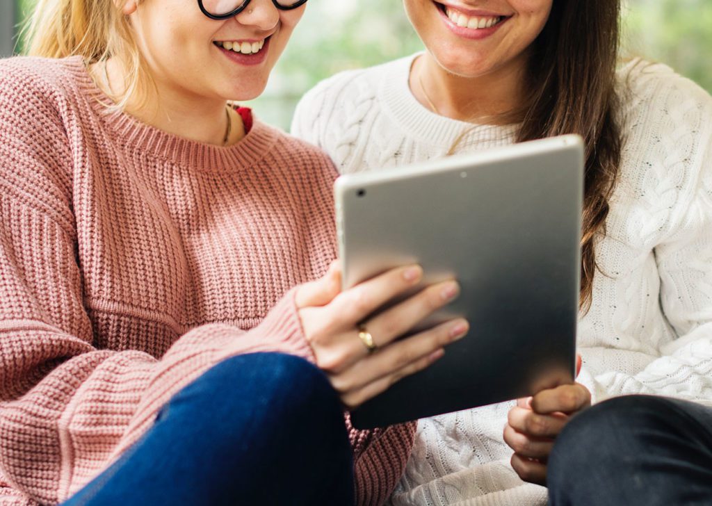 Two women looking at iPad.