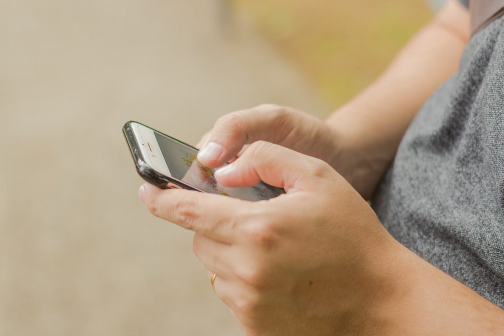 Man’s hands using phone.