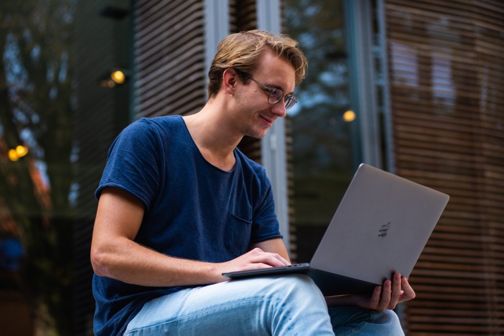 Man using computer outside.