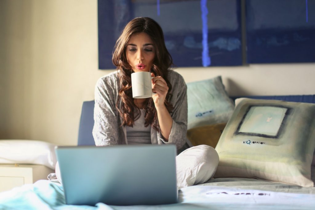 Woman on bed using computer.