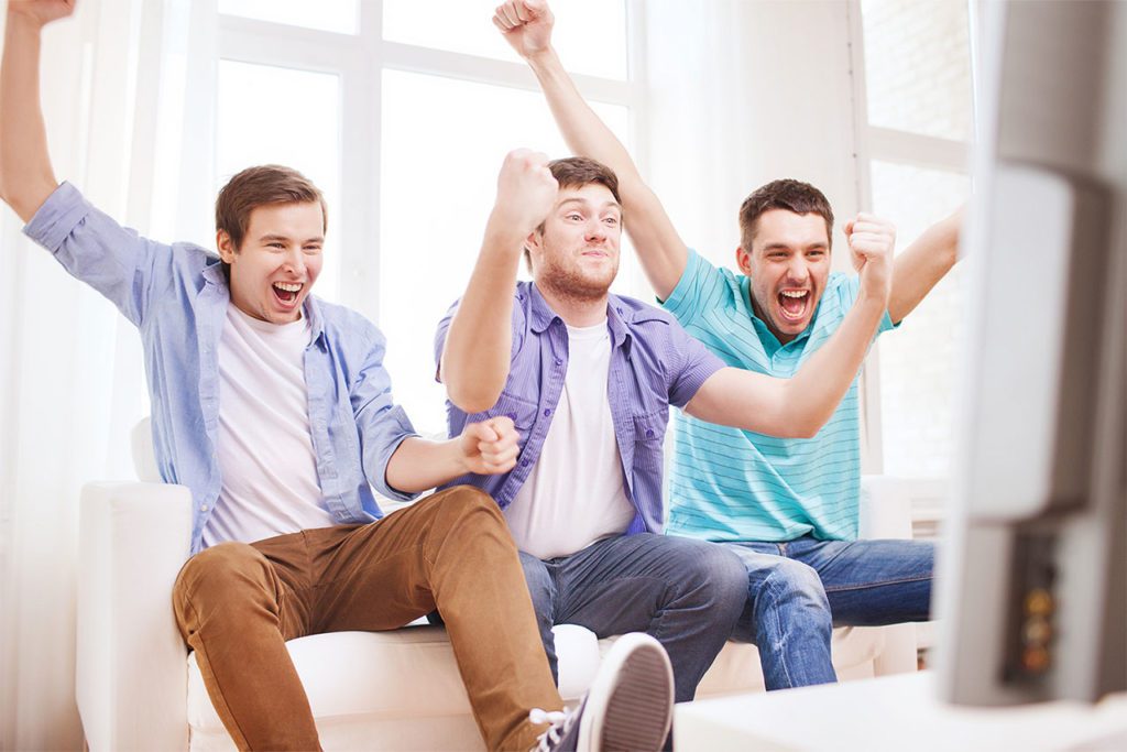 Men on couch cheering.
