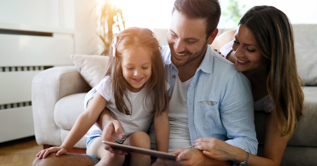 Small family looking at tablet.