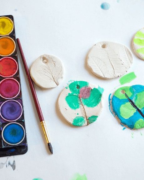 Kids craft of painted leaf imprinted clay.