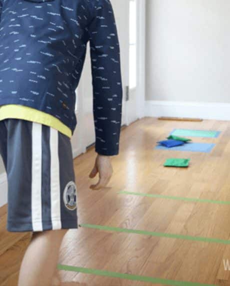 Boy playing bean bag toss game.