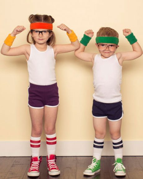Young girl and boy wear gym outfits and flex their biceps.