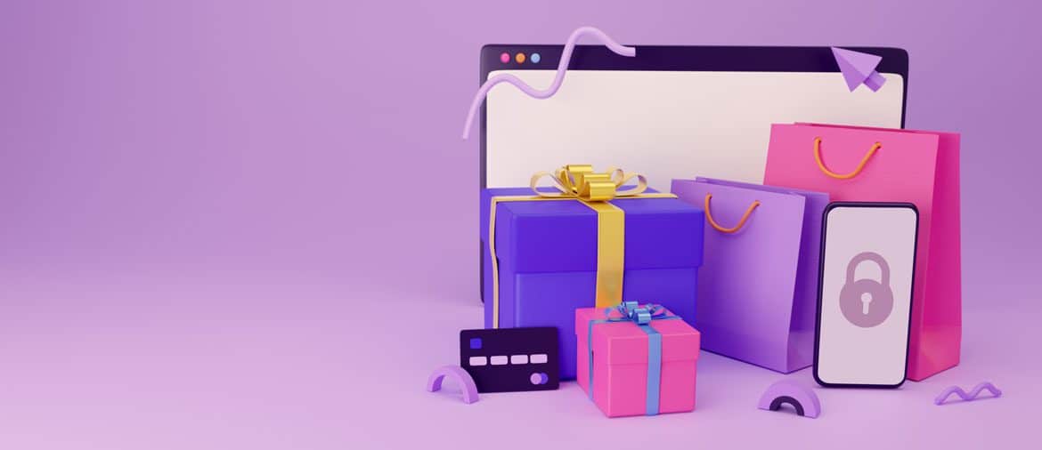 Gift boxes, bags, and a credit card sit by a smartphone and computer.