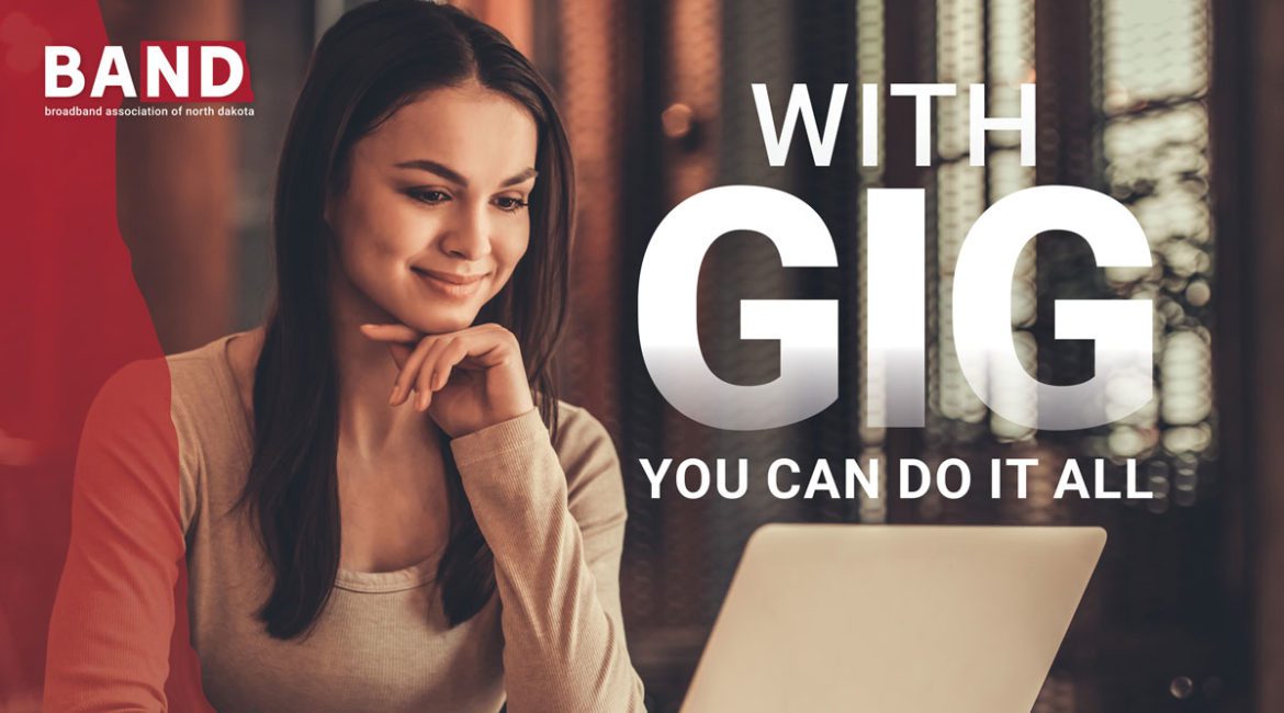 A young woman smiling while she browses the internet on her laptop.