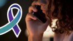 A girl talks on her cell phone with a graphic of the National Suicide Prevention Lifeline ribbon next to her.