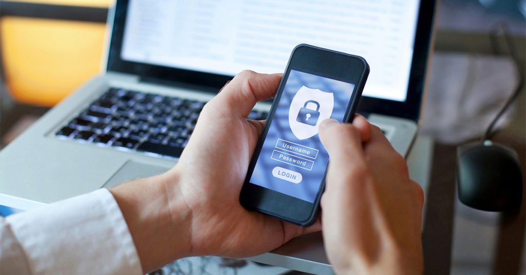 A closeup of a person’s hands holding a locked mobile device