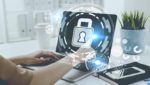 Open laptop with transparent cybersecurity image glowing from screen