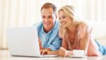 Husband and wife looking at a laptop and smiling