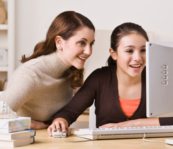 Mom and daughter looking at something on the computer and smiling