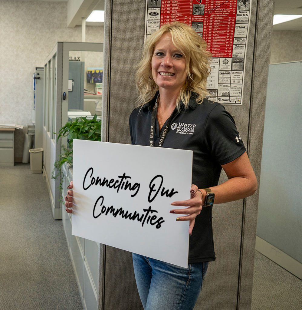 UTMA employee holding a Connecting Our Communities sign