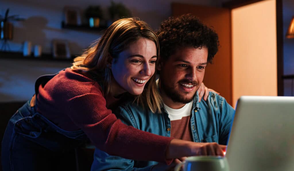 Two adults looking at a laptop together