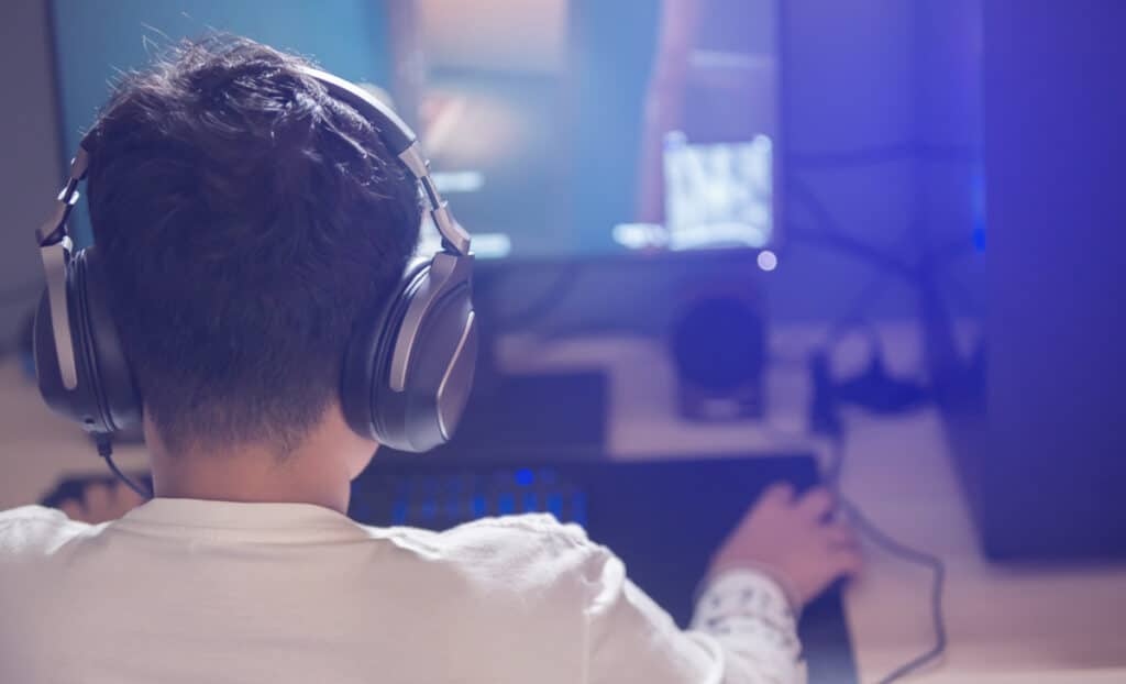 A young boy playing video games on a desktop computer