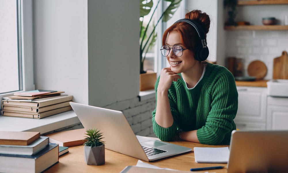 woman using internet on laptop - fiber-optic internet vs. 5G