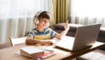 Young boy with headphones on using laptop