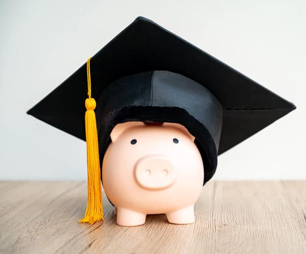 A piggy bank wearing a black graduation cap
